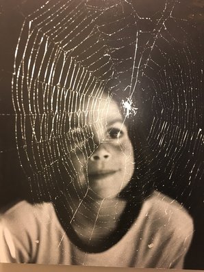 Black and white photo of girl looking at spiderweb