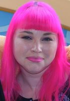 Woman with pink hair smiling at camera