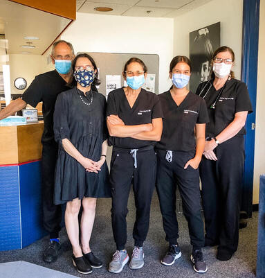 Five doctors standing together wearing masks